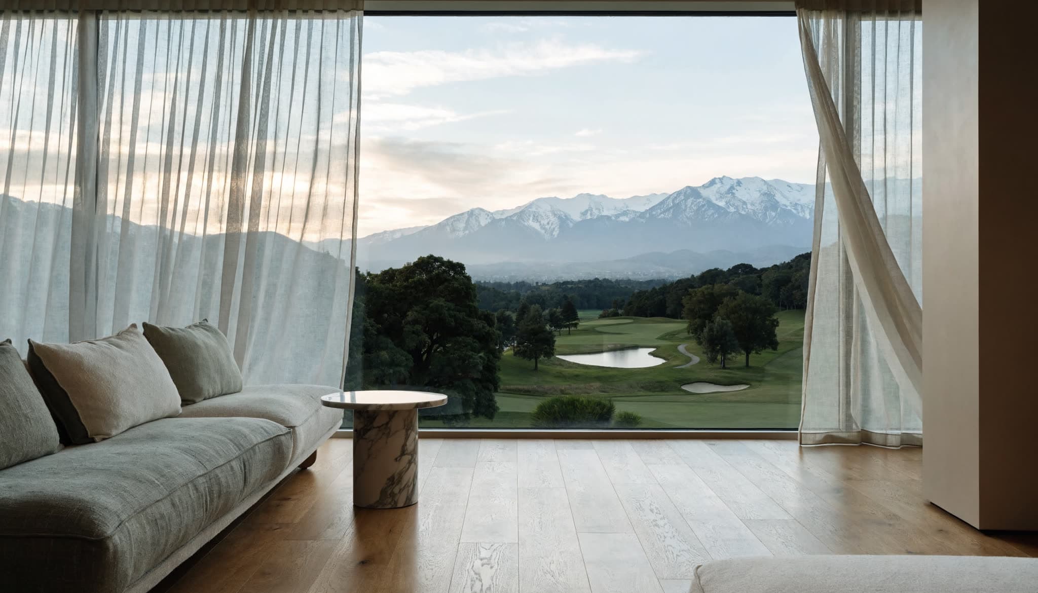 Ventanal de un departamento abierto al paisaje del club de golf